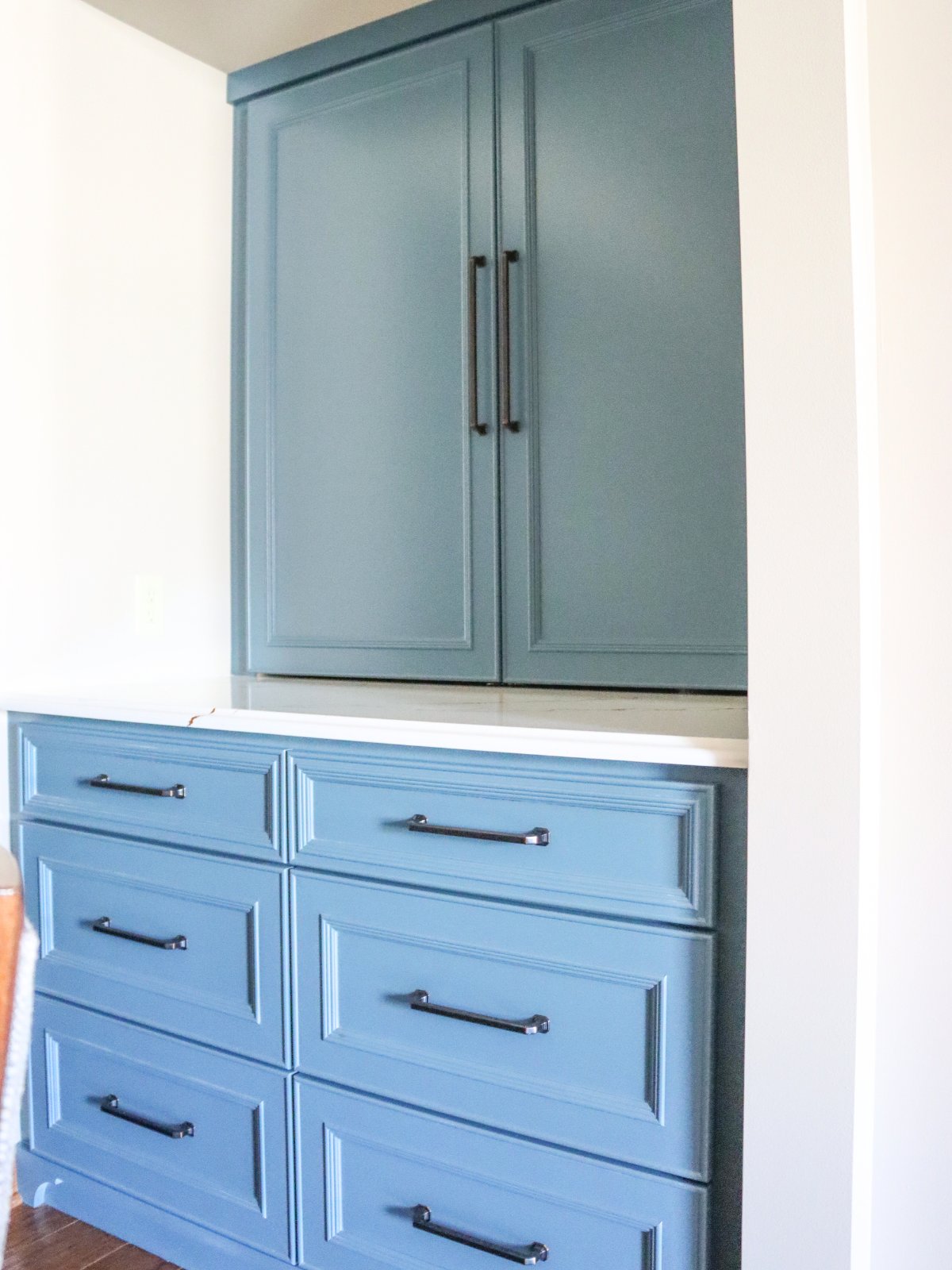 Custom built-in breakfast nook with blue cabinetry and coffee bar in Lincoln condo.