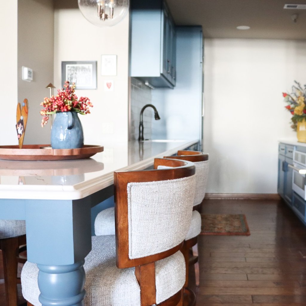 Blue custom cabinetry in Lincoln condo kitchen featuring a counter-height breakfast bar with bar stools.