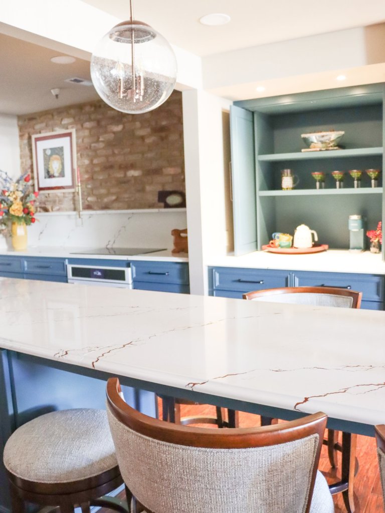 Full view of custom walnut paneled built-in with electric fireplace and mounted TV in Lincoln condo living space.