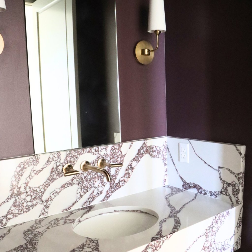 Powder bath with maroon walls and modern fixtures in custom home.
