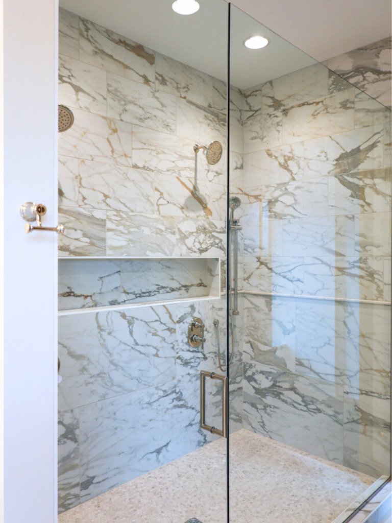 Primary suite walk-in shower in custom Elkhorn home featuring modern finishes.
