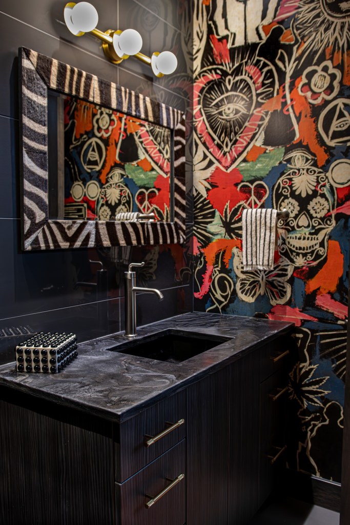 Wild eclectic wall covering and edgy decor in a downtown Omaha condo full bath.