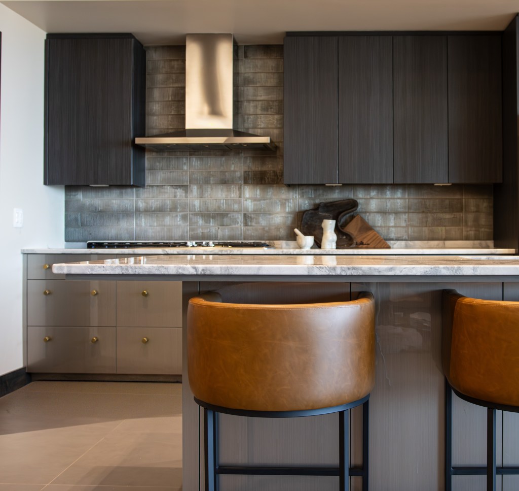 Cool-toned kitchen design featuring a high-texture tile backsplash and unique decor accents.